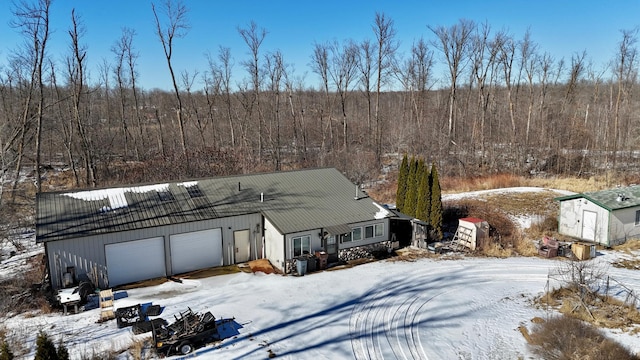 exterior space with a garage and a view of trees