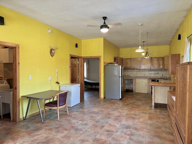 kitchen featuring decorative light fixtures, backsplash, refrigerator, freestanding refrigerator, and ceiling fan