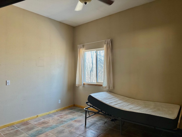 unfurnished room featuring a ceiling fan and baseboards