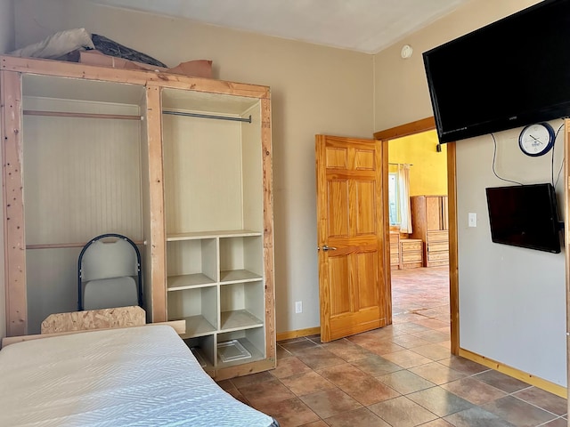 bedroom with baseboards and tile patterned flooring