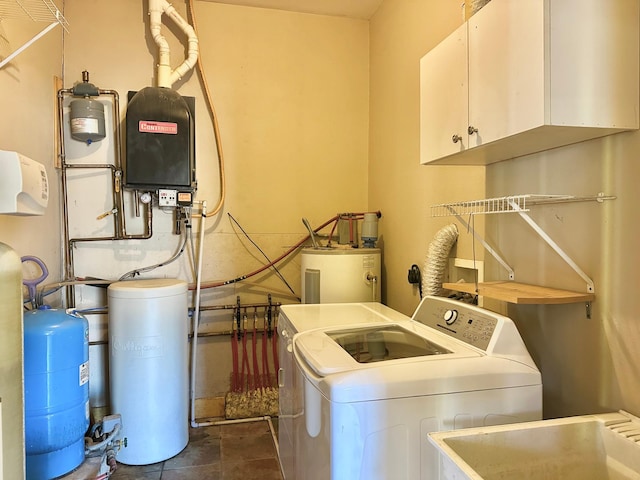 laundry room featuring cabinet space, washing machine and dryer, electric water heater, and a sink