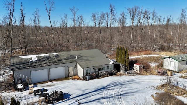 exterior space featuring a view of trees and a garage