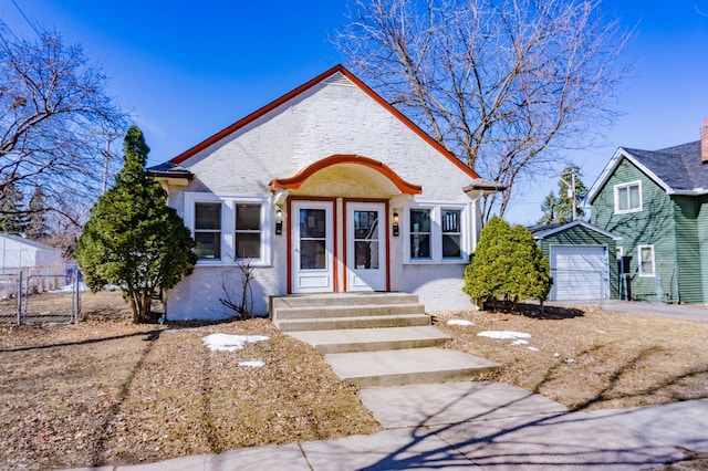 view of front of home with an outbuilding, fence, driveway, and a detached garage