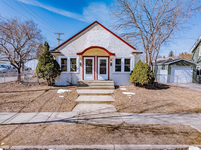 bungalow-style home featuring an outdoor structure, fence, and a garage