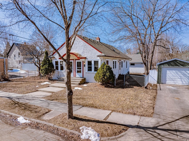 view of front of home with an outbuilding, a chimney, a garage, and fence