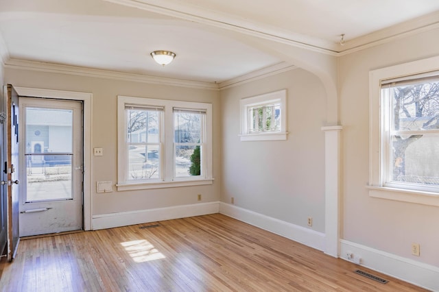 entryway featuring visible vents, baseboards, light wood-style floors, and ornamental molding