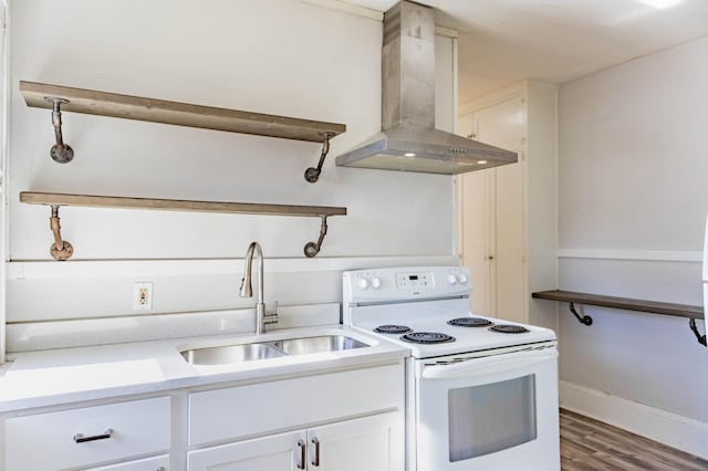 kitchen with wood finished floors, a sink, white cabinetry, wall chimney exhaust hood, and white electric range