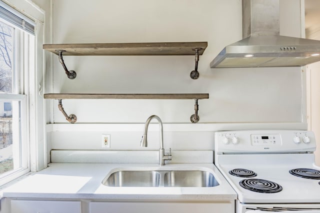 kitchen with wall chimney exhaust hood, light countertops, electric stove, and a sink