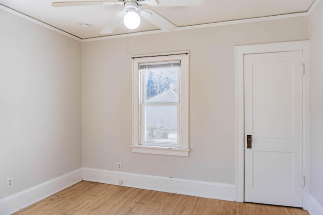 spare room featuring a ceiling fan, baseboards, and light wood finished floors