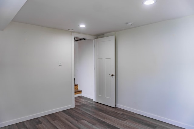 spare room featuring stairway, recessed lighting, dark wood-type flooring, and baseboards