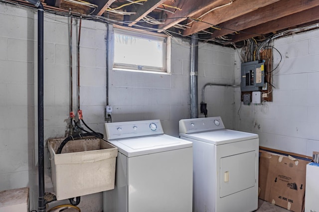 laundry room with electric panel, laundry area, washing machine and clothes dryer, and a sink