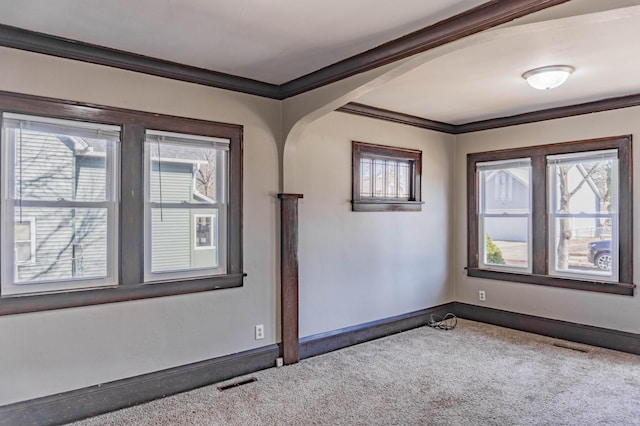 carpeted spare room with visible vents, baseboards, and ornamental molding