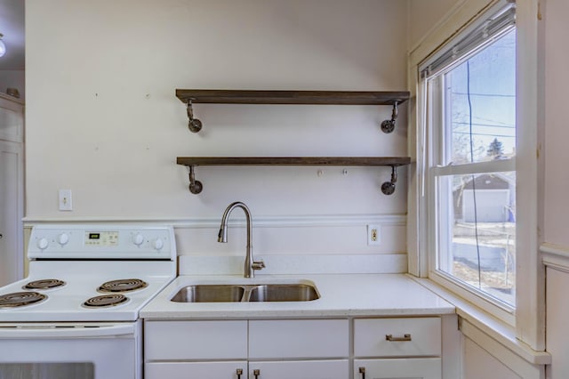 kitchen featuring a wealth of natural light, open shelves, a sink, white range with electric stovetop, and white cabinets