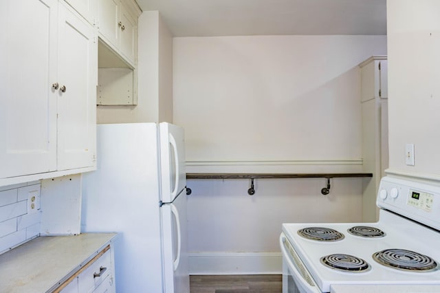 kitchen featuring baseboards, light countertops, wood finished floors, white appliances, and white cabinetry