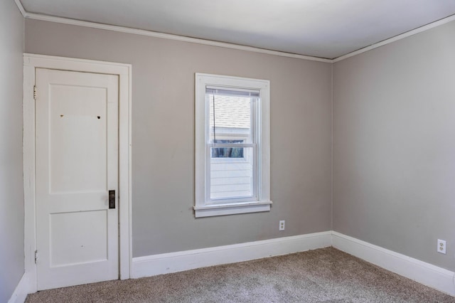 empty room featuring crown molding, baseboards, and carpet floors