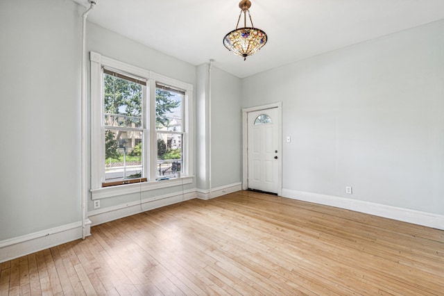 empty room featuring baseboards and wood-type flooring