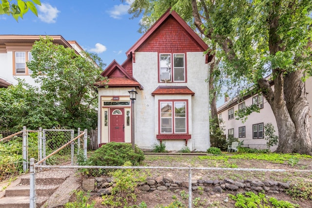 view of front of house with a gate, stucco siding, and fence