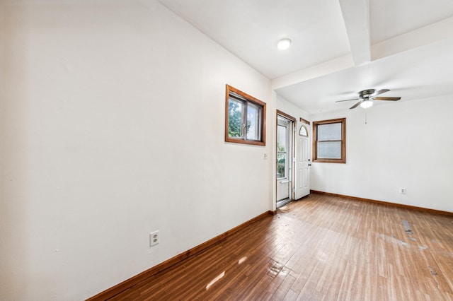 spare room with a ceiling fan, baseboards, and wood-type flooring