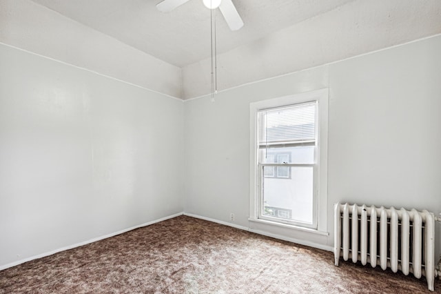 unfurnished room featuring a ceiling fan, radiator heating unit, carpet, baseboards, and vaulted ceiling