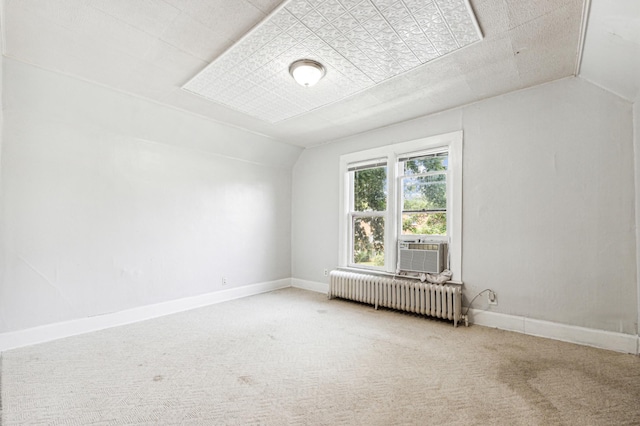 carpeted spare room featuring lofted ceiling, radiator heating unit, cooling unit, and baseboards