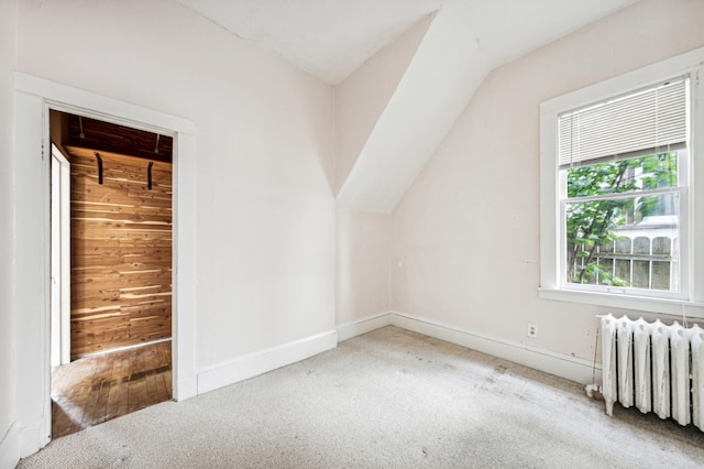 bonus room featuring carpet flooring, vaulted ceiling, radiator heating unit, and baseboards