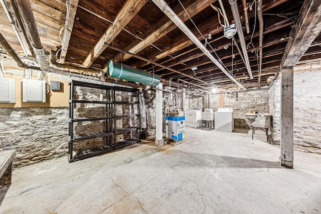 unfinished below grade area with independent washer and dryer and a sink