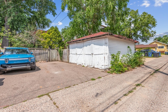 garage featuring a storage shed and fence