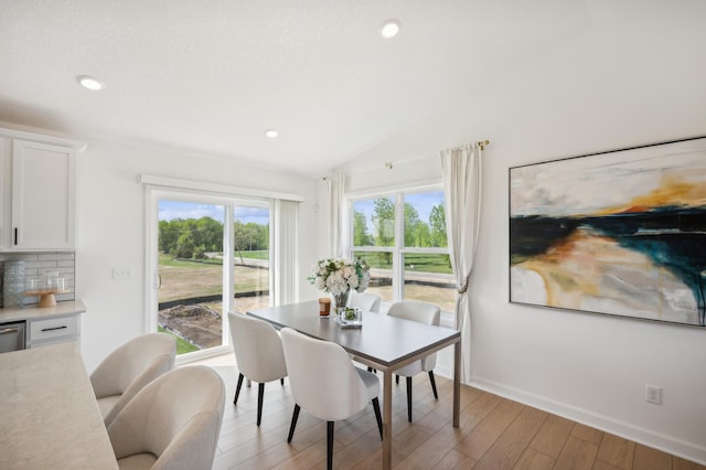 dining space with recessed lighting, baseboards, lofted ceiling, and light wood finished floors