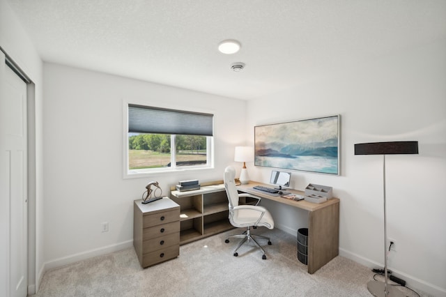 carpeted home office featuring baseboards