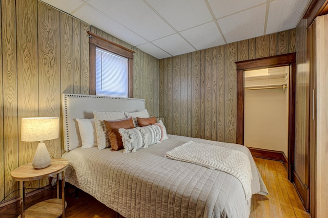 2538 Jefferson St NE, Minneapolis, MN 55418 - bedroom with hardwood / wood-style floors, wooden walls, a paneled ceiling, a closet, and a spacious closet
