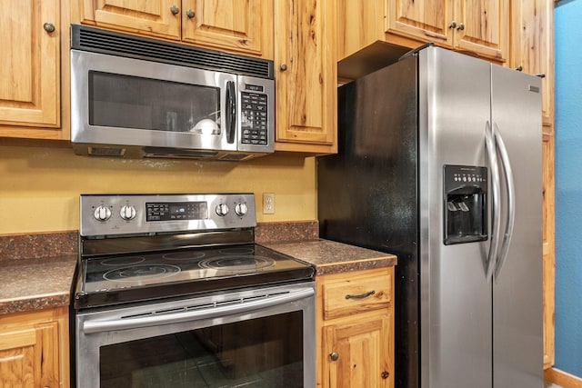 kitchen with dark countertops and appliances with stainless steel finishes