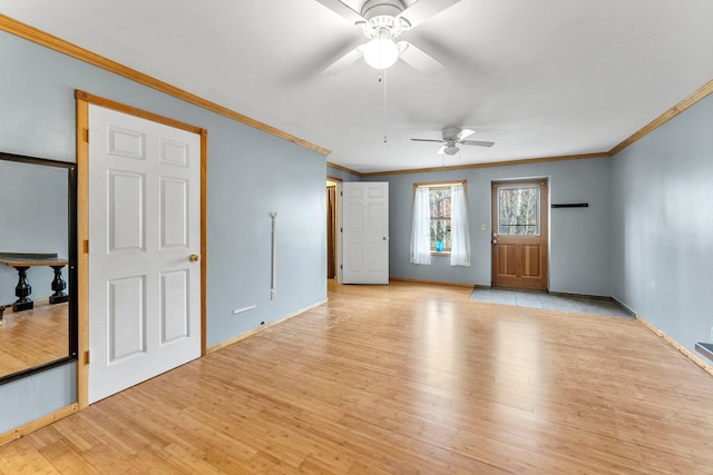 empty room featuring light wood-type flooring, baseboards, ornamental molding, and a ceiling fan