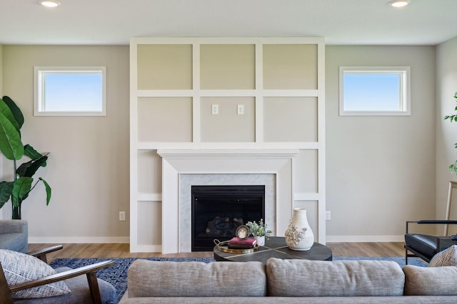 living area with wood finished floors, recessed lighting, a healthy amount of sunlight, and baseboards