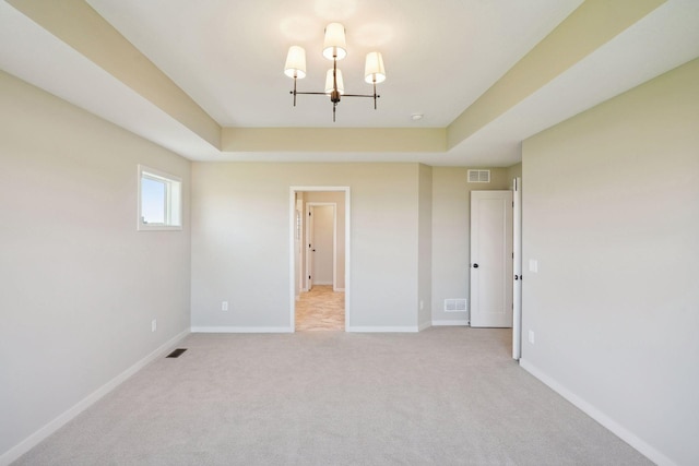 empty room with a notable chandelier, baseboards, visible vents, and light carpet