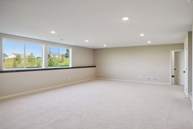 unfurnished room with recessed lighting, baseboards, light carpet, and visible vents