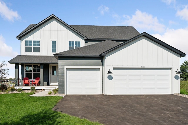 modern farmhouse featuring a garage, board and batten siding, and driveway