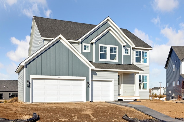 view of front of property with roof with shingles, board and batten siding, and driveway