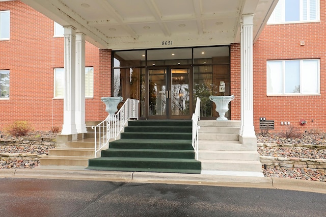 doorway to property featuring brick siding