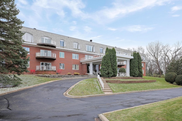 view of property featuring aphalt driveway and stairway