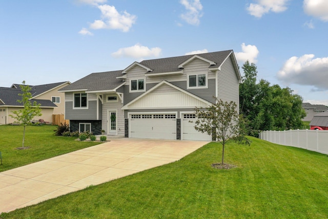 view of front of house featuring an attached garage, a front lawn, fence, stone siding, and driveway