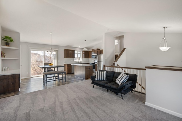 interior space featuring vaulted ceiling, wood finished floors, carpet, and baseboards