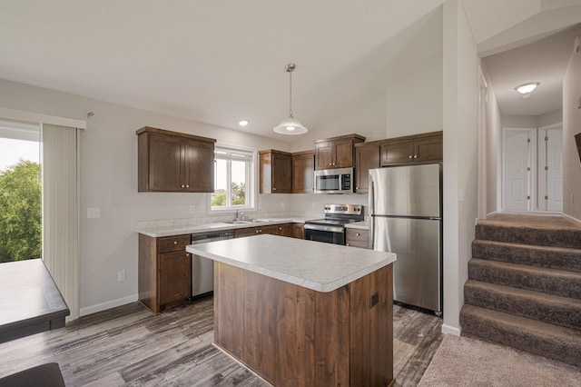 kitchen with light countertops, dark brown cabinets, dark wood-style floors, and appliances with stainless steel finishes