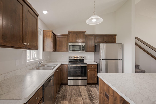 kitchen featuring dark wood-style floors, lofted ceiling, a sink, stainless steel appliances, and light countertops