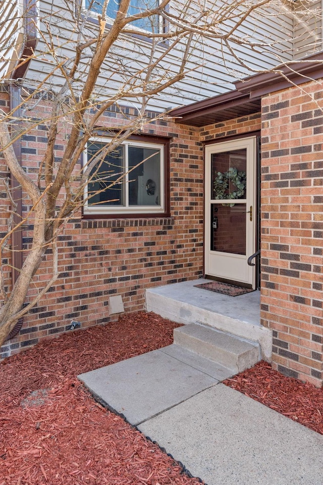 view of exterior entry with brick siding