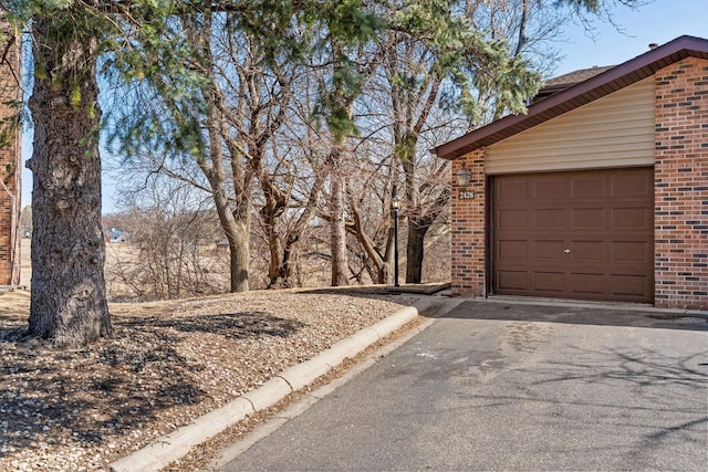 view of side of home with brick siding and asphalt driveway