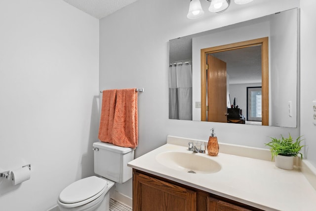 full bath featuring toilet, vanity, baseboards, and a textured ceiling