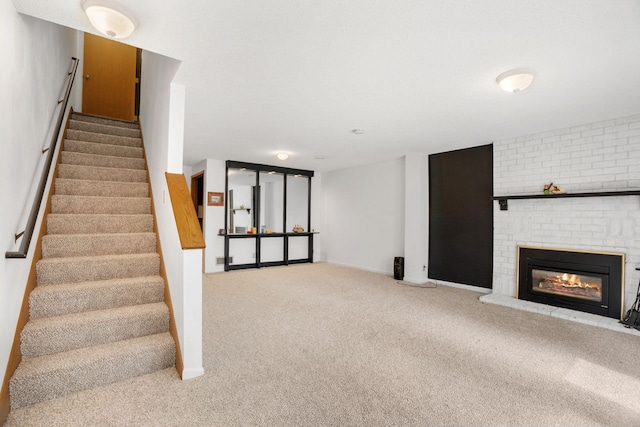stairway featuring carpet flooring, a fireplace, and baseboards