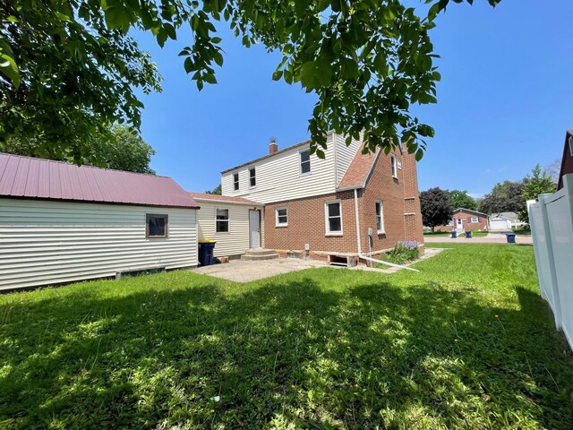 421 Van Dusen St, Springfield, MN 56087 - rear view of property featuring a patio, a yard, and a chimney
