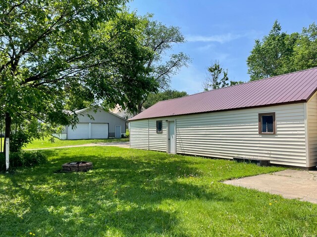 421 Van Dusen St, Springfield, MN 56087 - view of green lawn with a garage, an outdoor fire pit, and an outbuilding