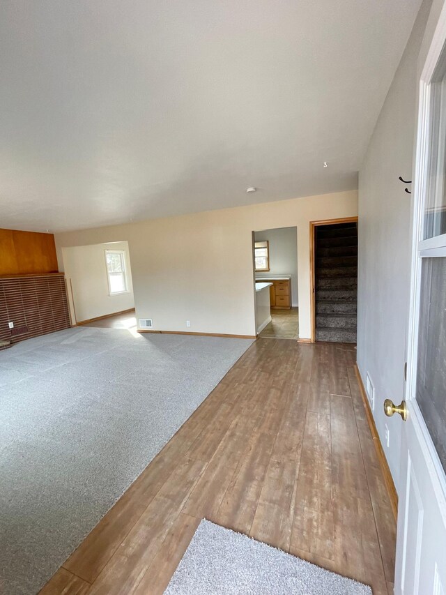 421 Van Dusen St, Springfield, MN 56087 - unfurnished living room with hardwood / wood-style floors, baseboards, and stairway